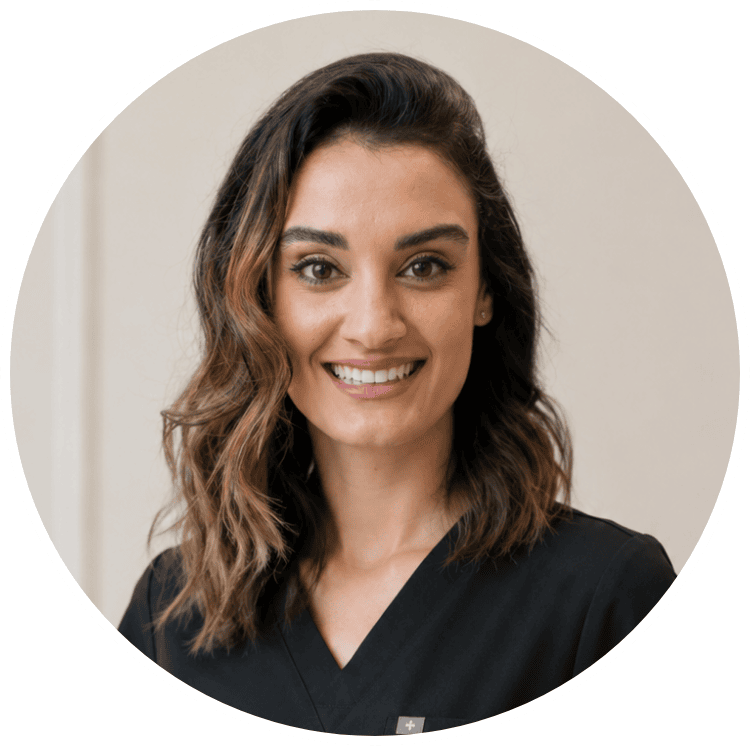 Smiling female dental professional in black scrubs at Enamelle Dental clinic.